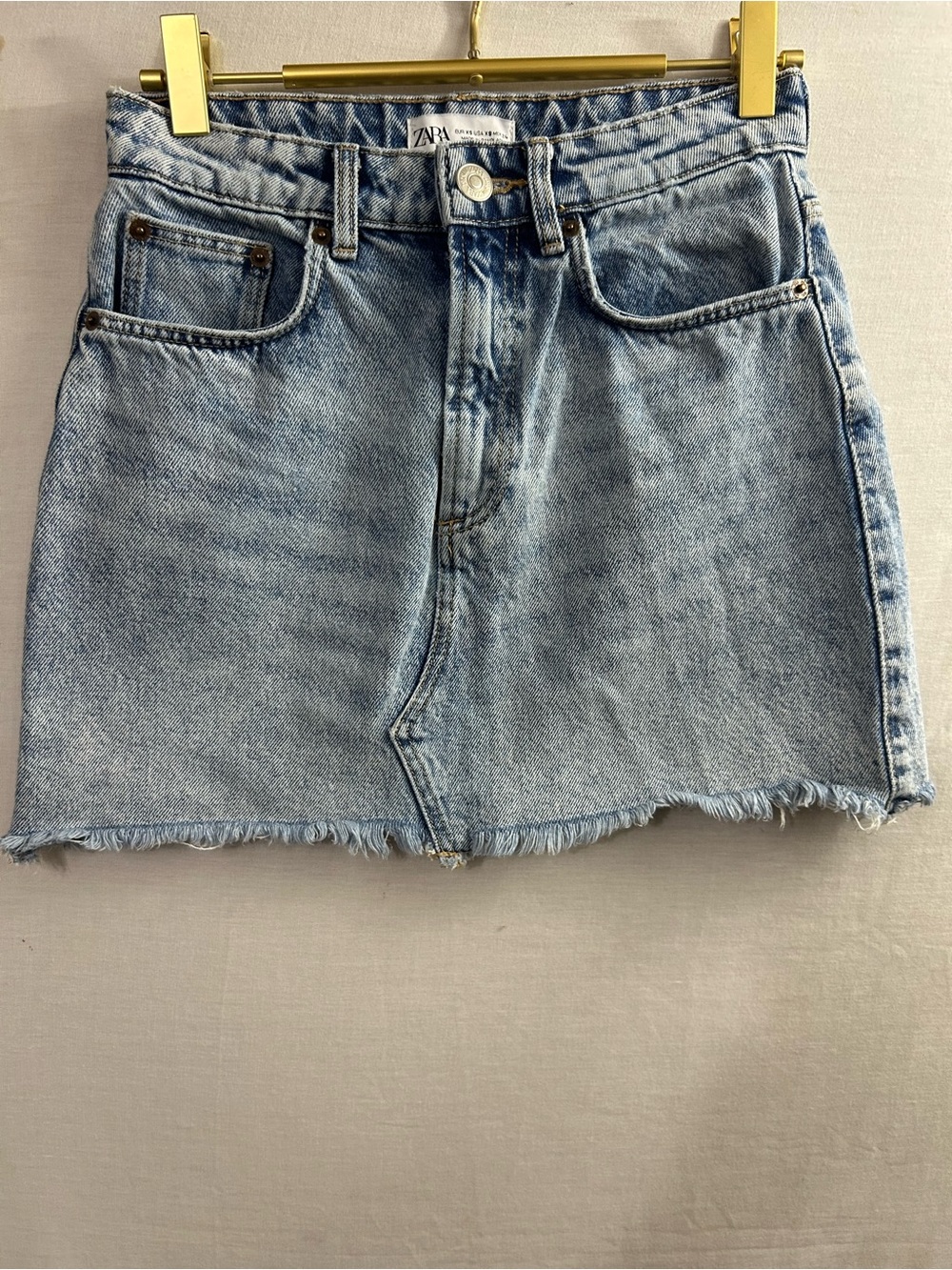 Zara denim skirt featuring a frayed hem and a light wash finish